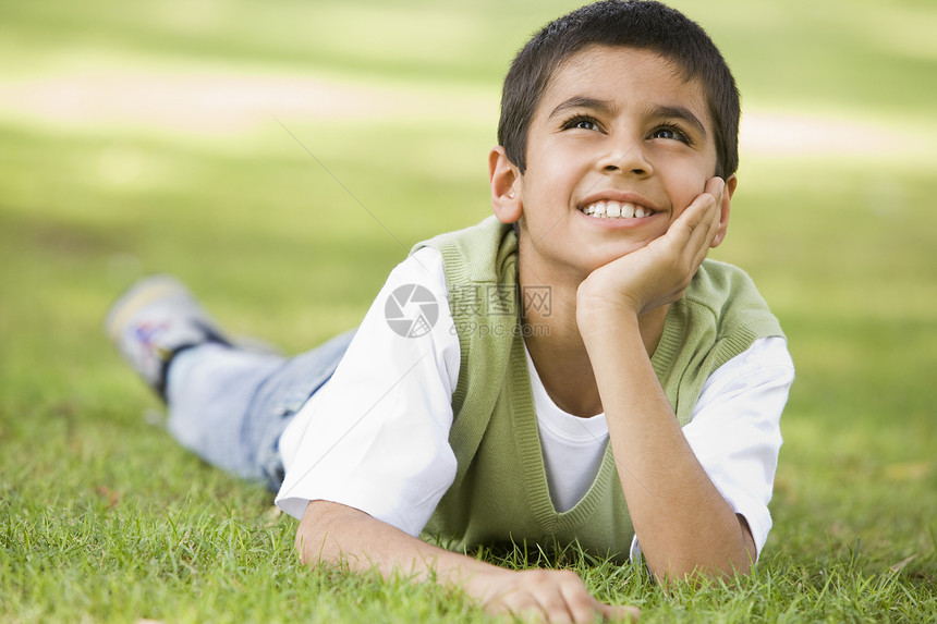 年轻男孩户外躺在草地上微笑焦距年龄和平情绪闲暇小学生孩子们水平阶段男性图片