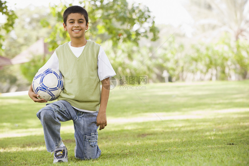 在公园户外的年轻男孩 抱着球和微笑阶段男性种族孩子们活动练习焦距情绪小学生体育图片