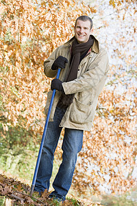 男人在户外磨着树叶和微笑情感中年后院花园男士男性叶子成年人人种幸福园艺高清图片素材