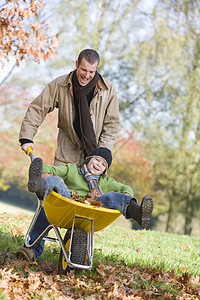 男人和男孩在户外玩手推车 微笑美化工具高清图片素材