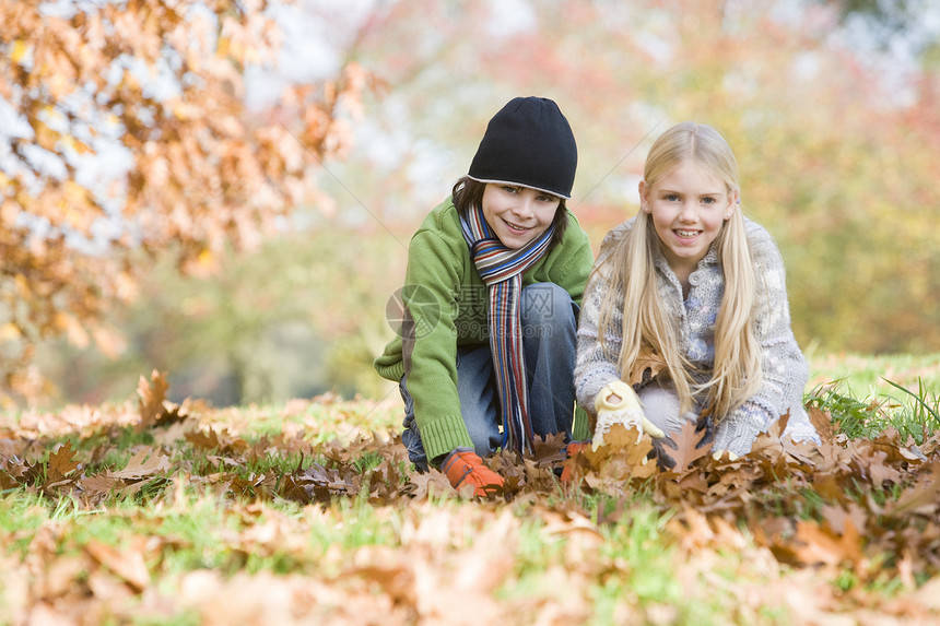 在公园户外玩叶子 笑着玩耍的两名儿童图片