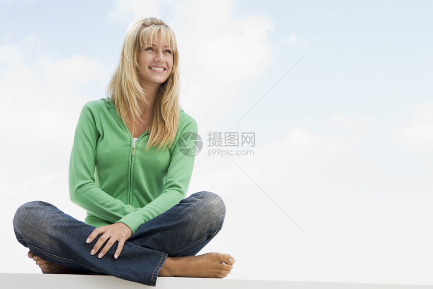 坐在外边的青年妇女休闲服微笑蓝天服装休闲女性中年人相机成人活力图片