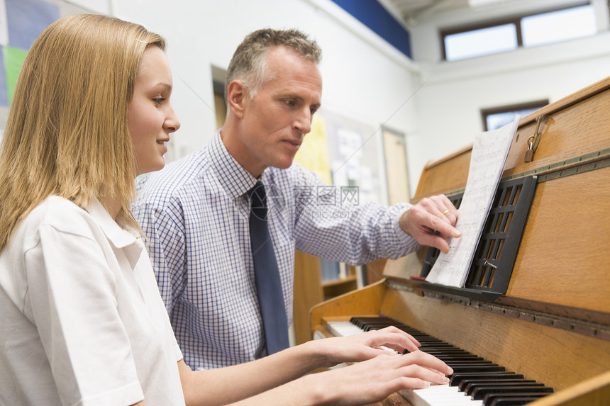 女学生在课堂上与教师一起学习钢琴图片