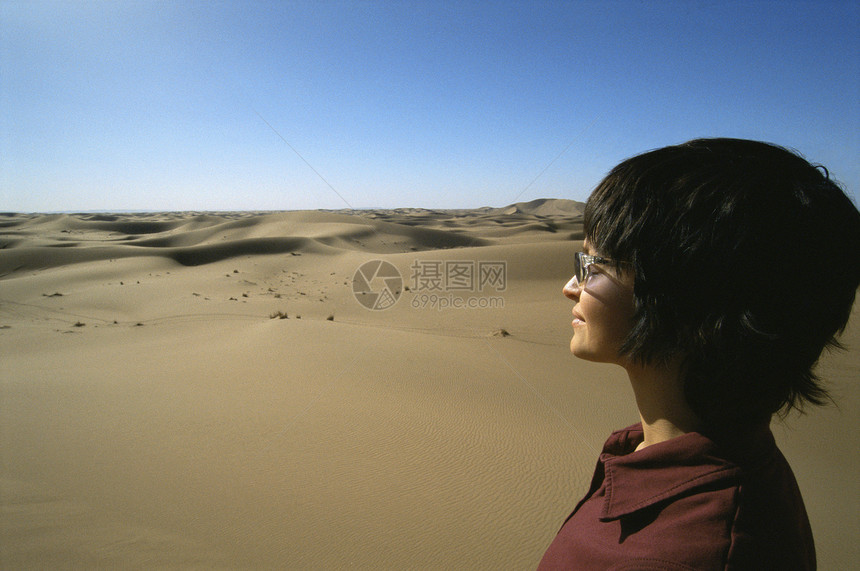 露户妇女站在沙漠中图片