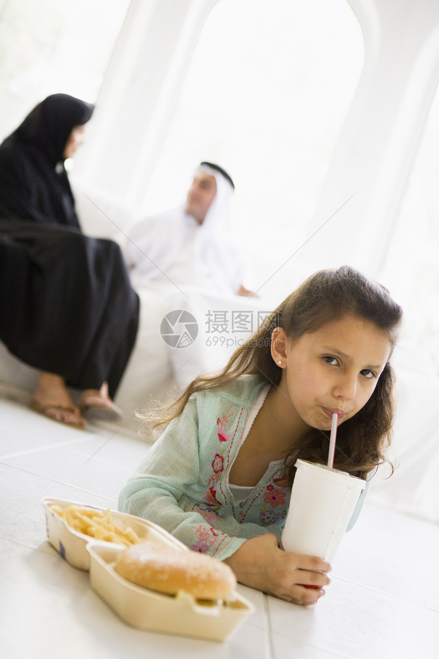 有背景父母在客厅里吃快餐的年轻女孩高关键选择性重点饮料孩子视角孩子们人种汉堡成人外表成年人窗户图片