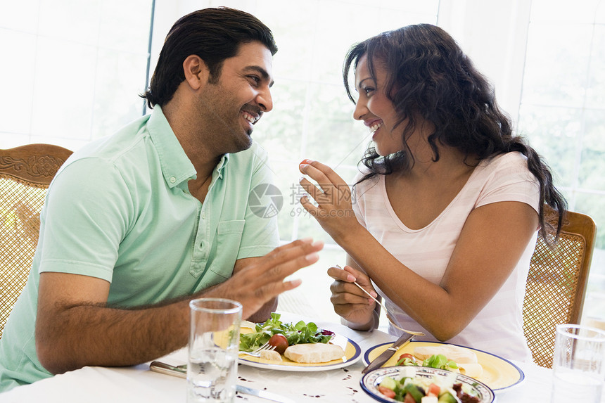 坐在晚餐桌边的情侣微笑高键食品食物成人玻璃夫妻美食情绪男朋友眼镜饮料图片