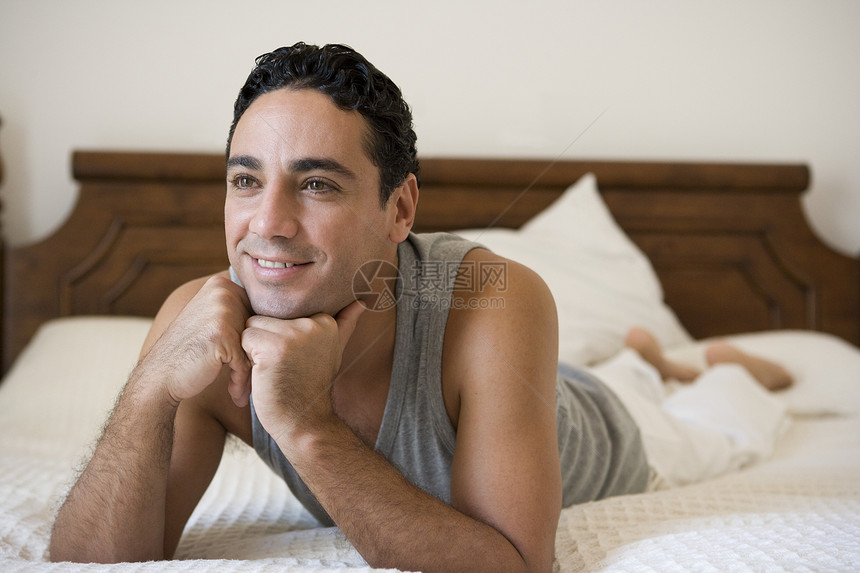 男人在床上放松 在卧室微笑选择性焦点视角情感情绪成人房屋双人床焦距特写镜头幸福图片