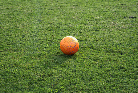 足球场上的球沥青场地橙色绿色背景图片