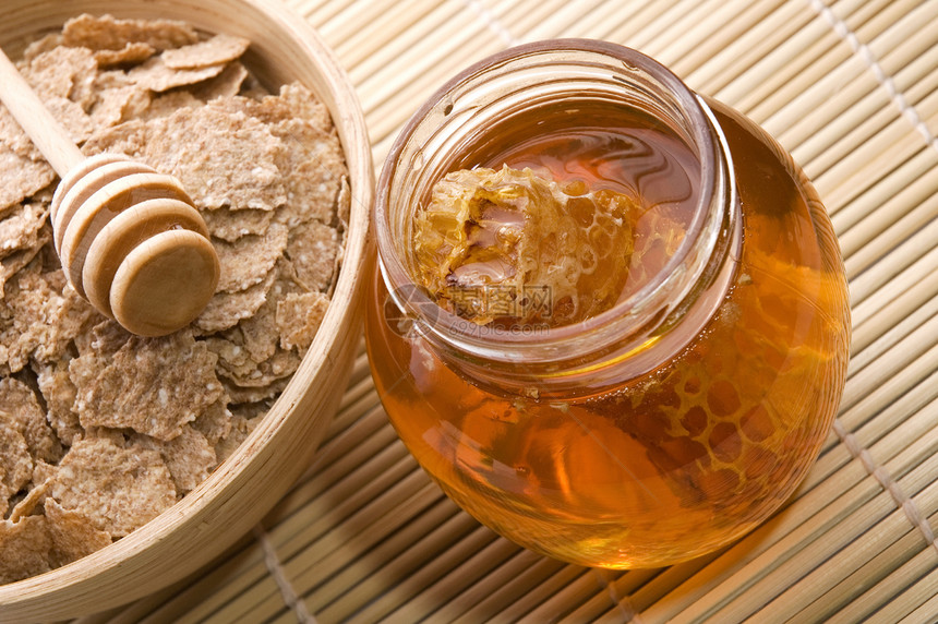 带蜂窝和早餐薄片的新鲜蜂蜜药品厨房液体甜点宏观玻璃梳子糖浆橙子玉米图片
