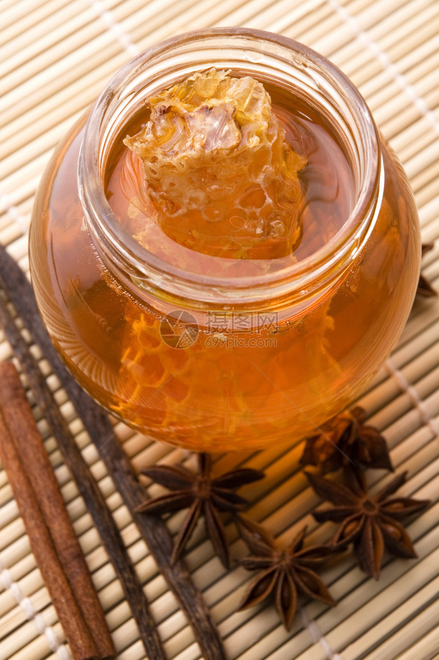 带蜂窝和香料的新鲜蜂蜜甜点玻璃梳子饮食液体八角橙子糖浆盘子肉桂图片