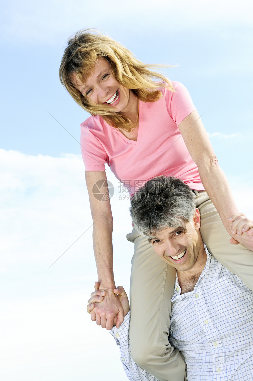 成熟的浪漫情侣男性活动海滩妻子肩膀丈夫假期骑术笑声微笑图片