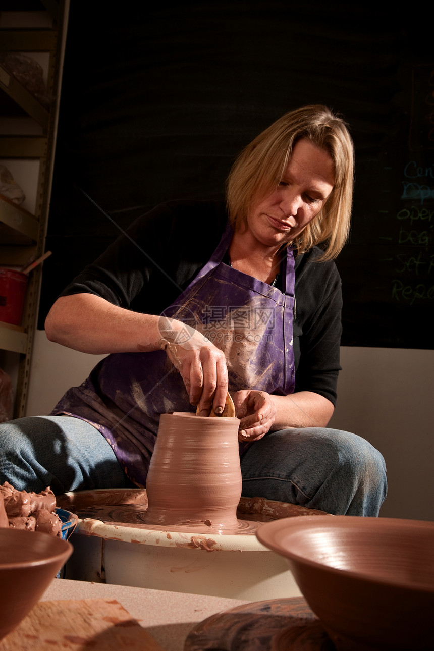 塑造粘土的波特地球女性制品罩衫工匠牛仔裤旋转微笑跳汰机陶器图片