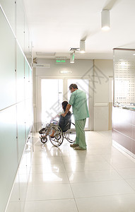 护士和使用轮椅的病人保险医疗医院擦洗走廊诊所卫生保健背景图片