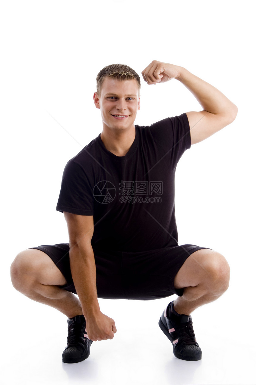 坐着的肌肉男展示他的肌肉图片