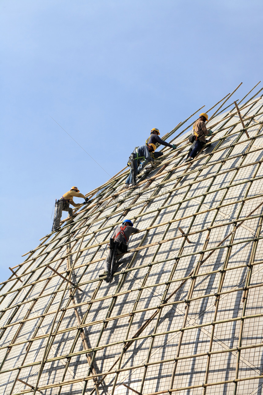 用竹子搭建一个脚手架工程师安全帽工作职场建筑工人日落安全保养职业图片