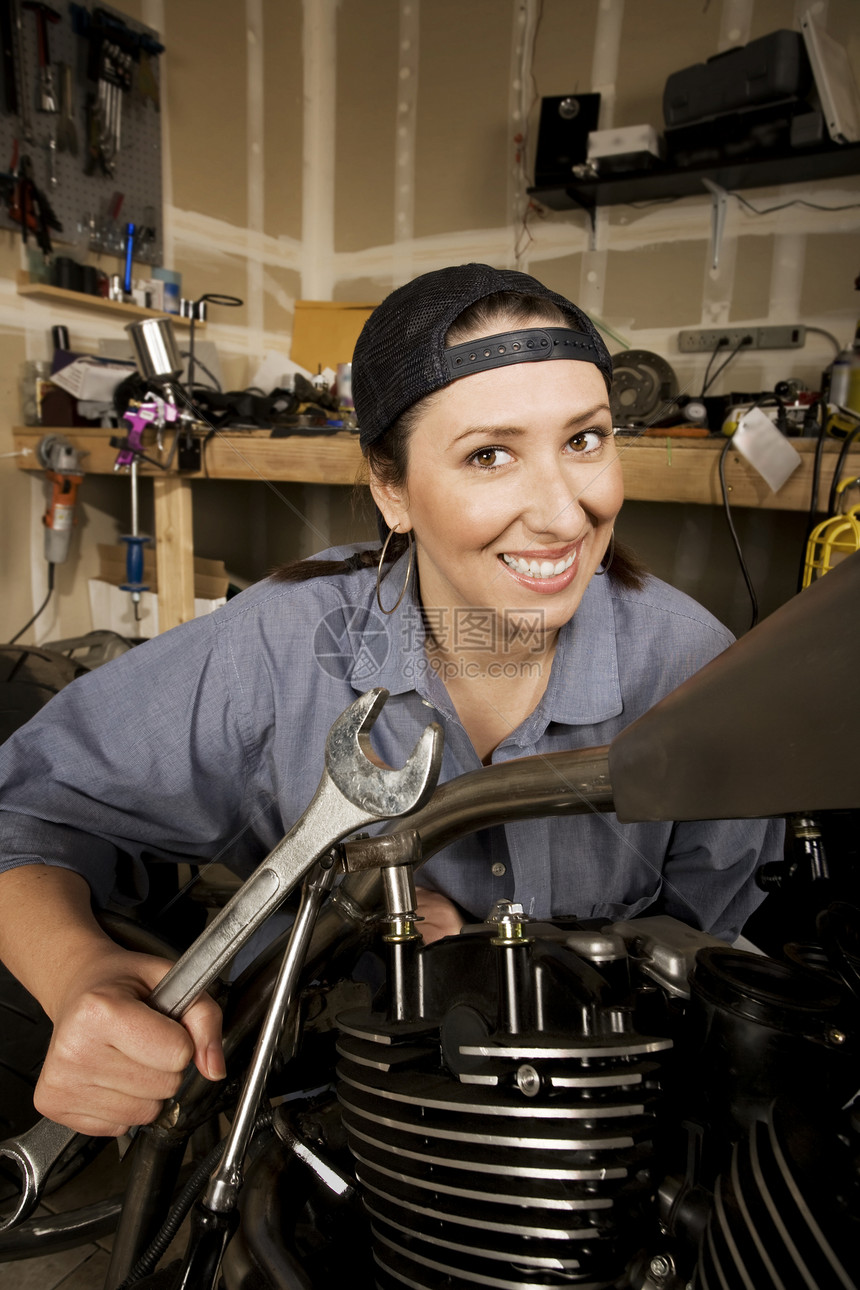 西班牙裔女性技工c运输能力女孩扳手帽子车库金属微笑摩托车引擎图片