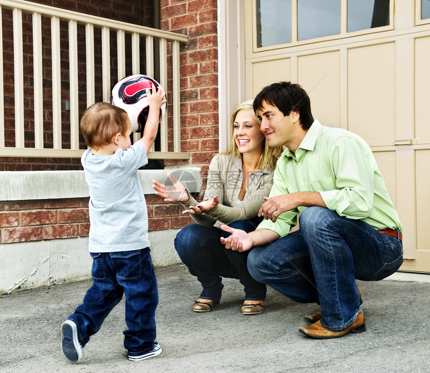 家庭玩足球的足球童年教学孩子们妈妈男人父母房子男性母亲车道图片