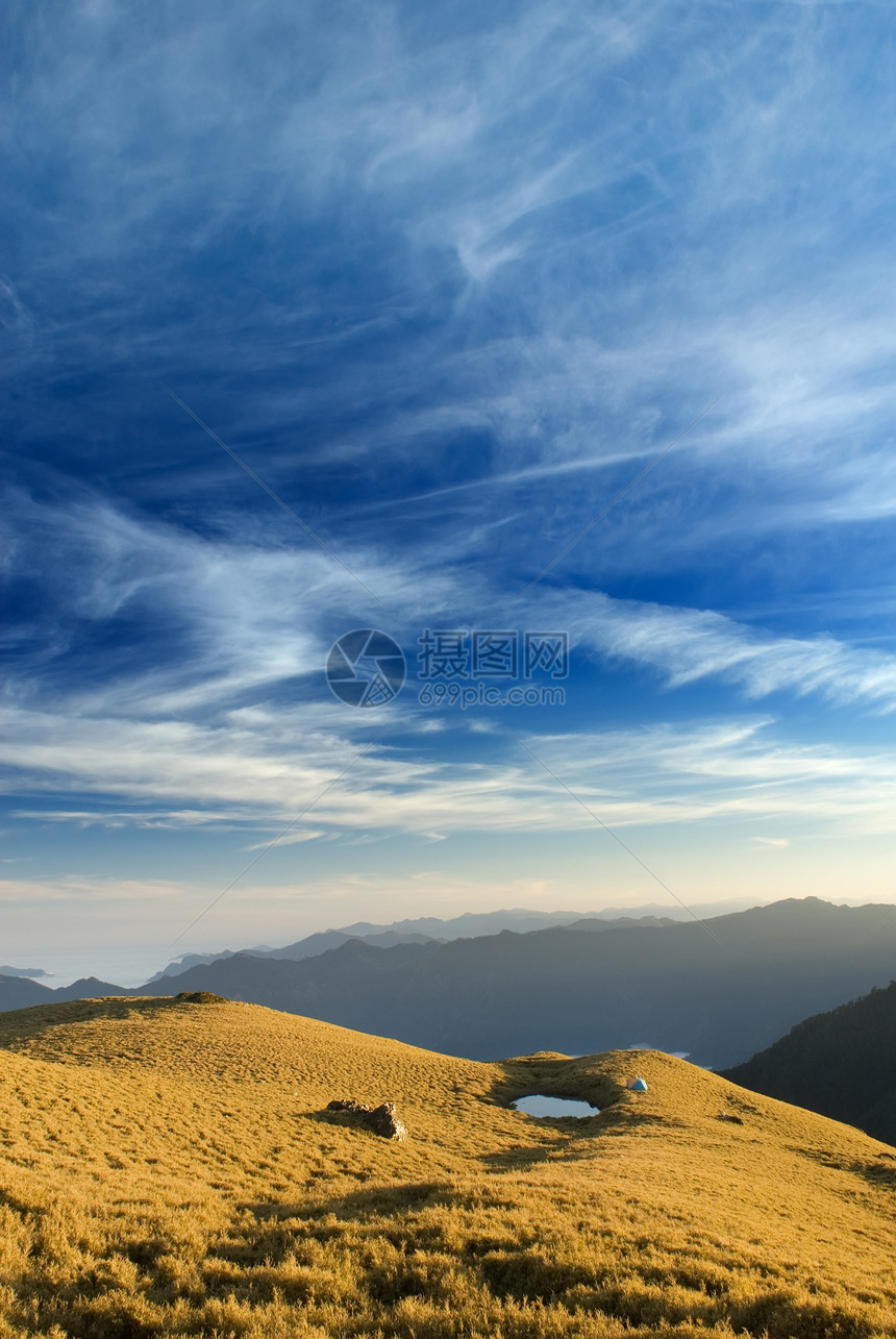 美丽的乌云在高山的草原上飞翔森林蓝色场地荒野天空地平线风景木头草地旅行图片