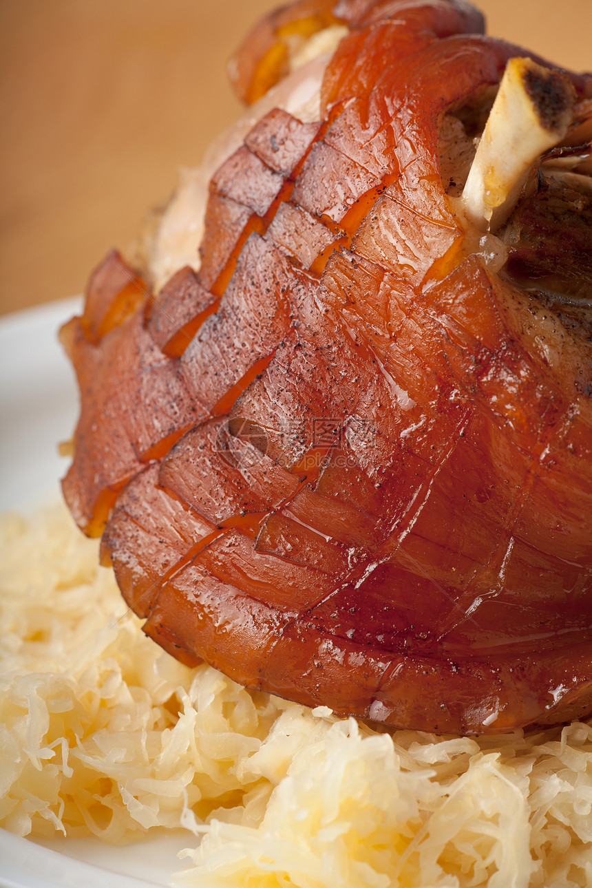木制桌上的烤猪肉肉汁桌子洋葱脆皮皮肤灰色食物斧头盘子猪肉图片