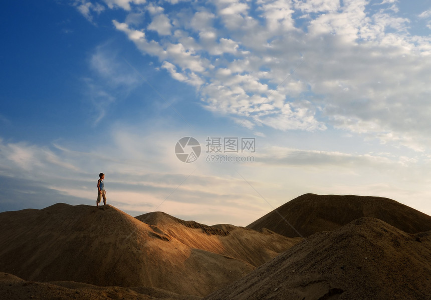 太阳下山的沙沙漠中的年轻人沙丘日出远足远足者游客日落旅行运动男生男性图片