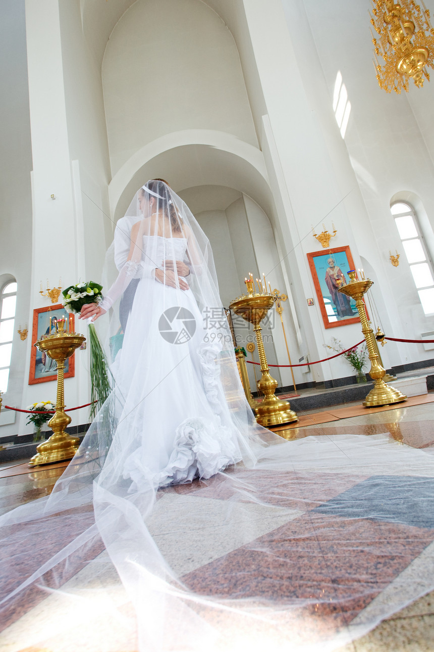 教堂中的新娘和新郎信仰祷告女士夫妻寺庙男性花束冥想吊灯精神图片