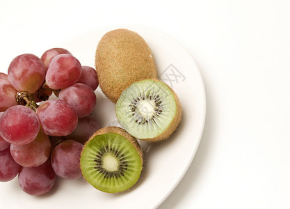 Kiwi和葡萄水果果汁奇异果红色种子热带盘子白色紫色绿色背景图片
