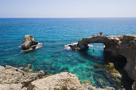 塞浦路斯海中的落岩拱门背景