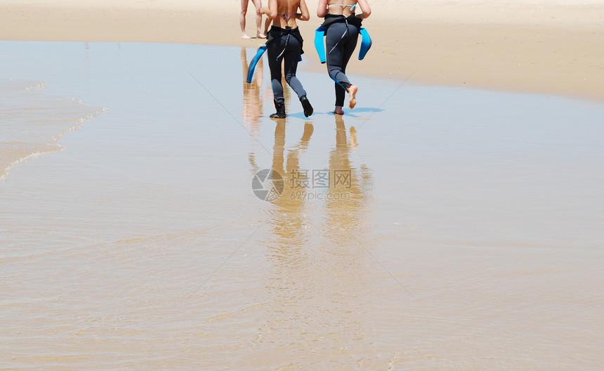 年轻冲浪者在海滩上行走图片