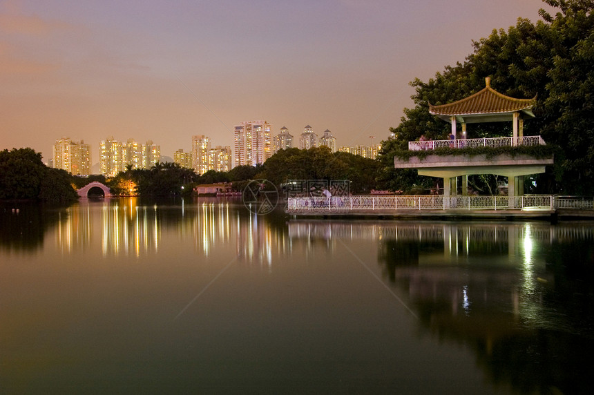 夜间在湖边公园池塘反射树木建筑物夜景发光亭子图片