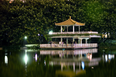 夜间在湖边公园池塘亭子反射发光建筑物夜景树木背景图片