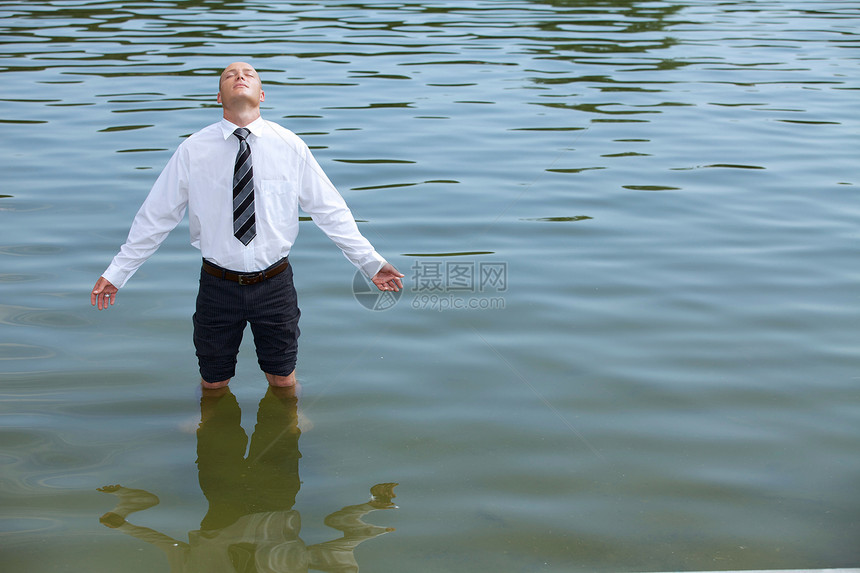 商务人士站在湖边 闭着眼睛图片