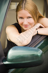 车上的漂亮女孩窗户女孩商务绿色驾驶金发女性金发女郎司机微笑背景图片