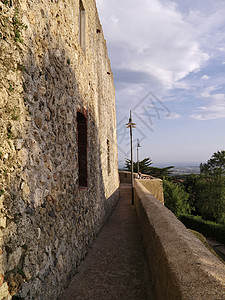 意大利 托斯卡纳 卡帕尔比奥镇 游客在外墙上放松和欣赏日落岩石建筑学遗产家园街道悬崖上坡楼梯城堡石头背景
