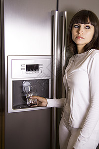 女人在冰箱前面的灰色的高清图片素材