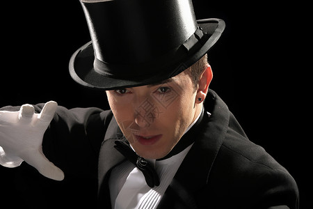 戴高帽的年轻魔术师套装游戏剧院手势诡计男性男人魔法乐趣帽子背景图片