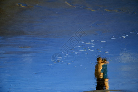 在海滩上黄色蓝色镜子女士男人反射波浪白色石头背景图片
