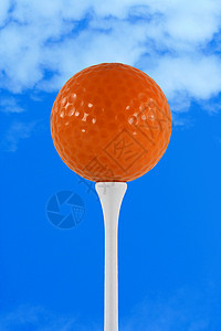 打击蓝天的橙色高尔夫球背景图片