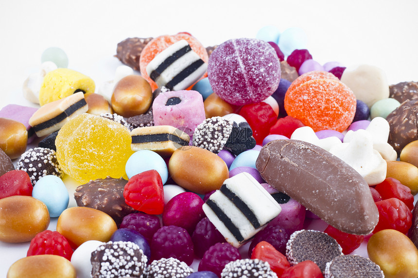 白背景上有很多糖果 鲜花零食紫色糖衣便利派对巧克力牙龈乐趣花絮多样性食物图片
