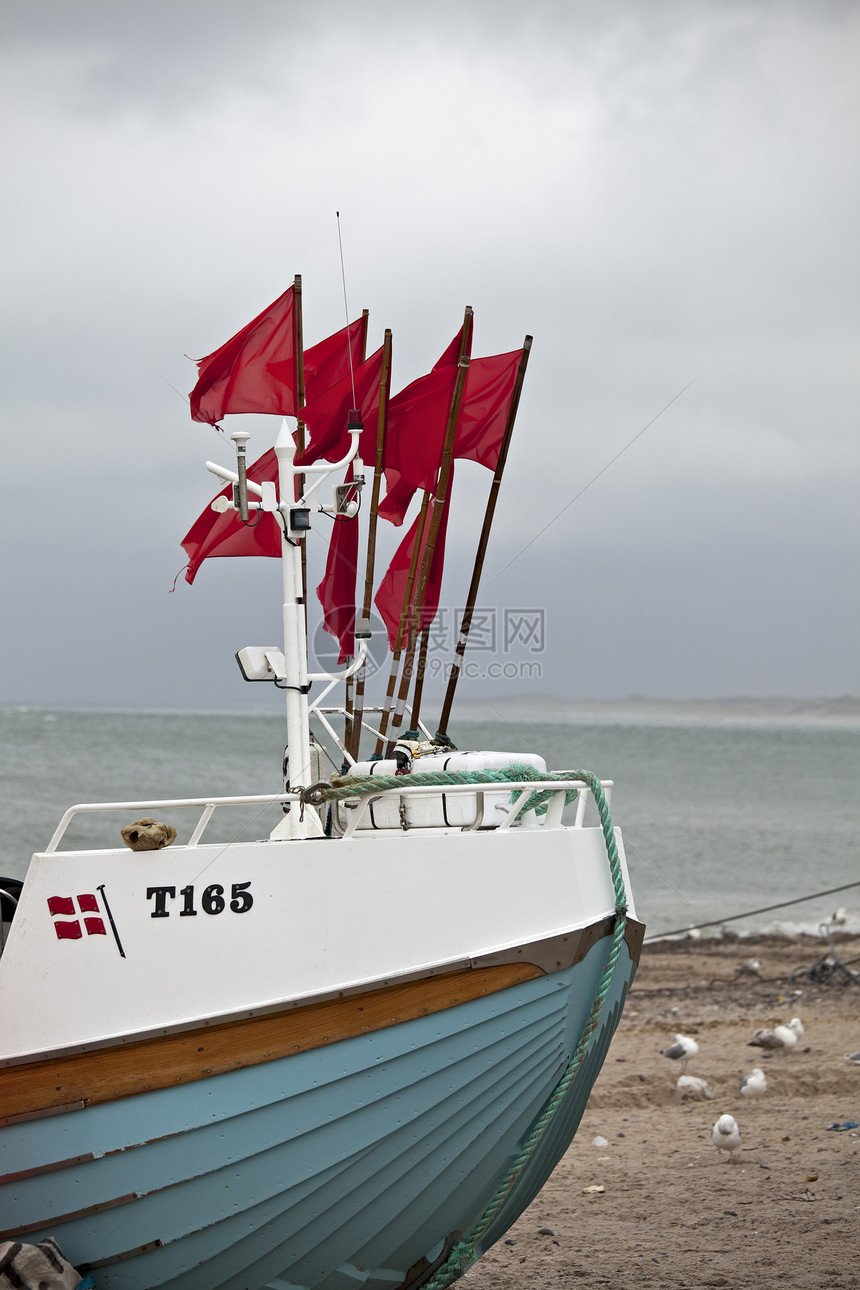 达尼鱼在海滩上的渔船船尾海岸血管航海绳索旗帜船运船体海洋运输图片