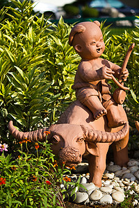 土器儿童和水牛棕色陶瓷艺术微笑烤箱陶器雕像手工石头工艺背景图片