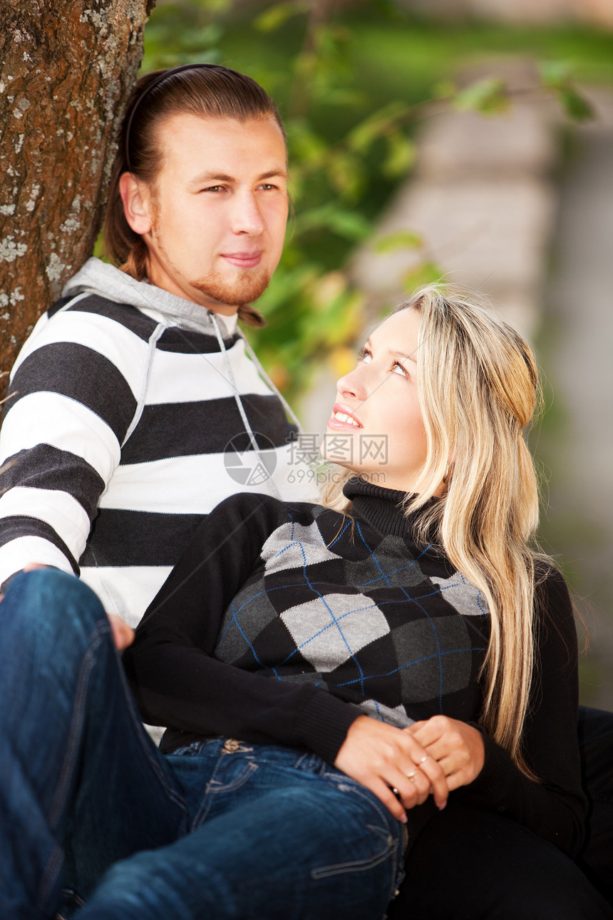 夫妇在户外休息女孩衣服女性牛仔裤毛衣男性树叶女士农村公园图片