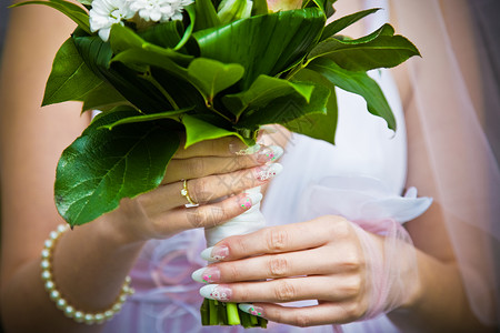 新娘抱着她的花束宏观衣服花朵婚姻美丽庆典皮革新人裙子夹克背景图片