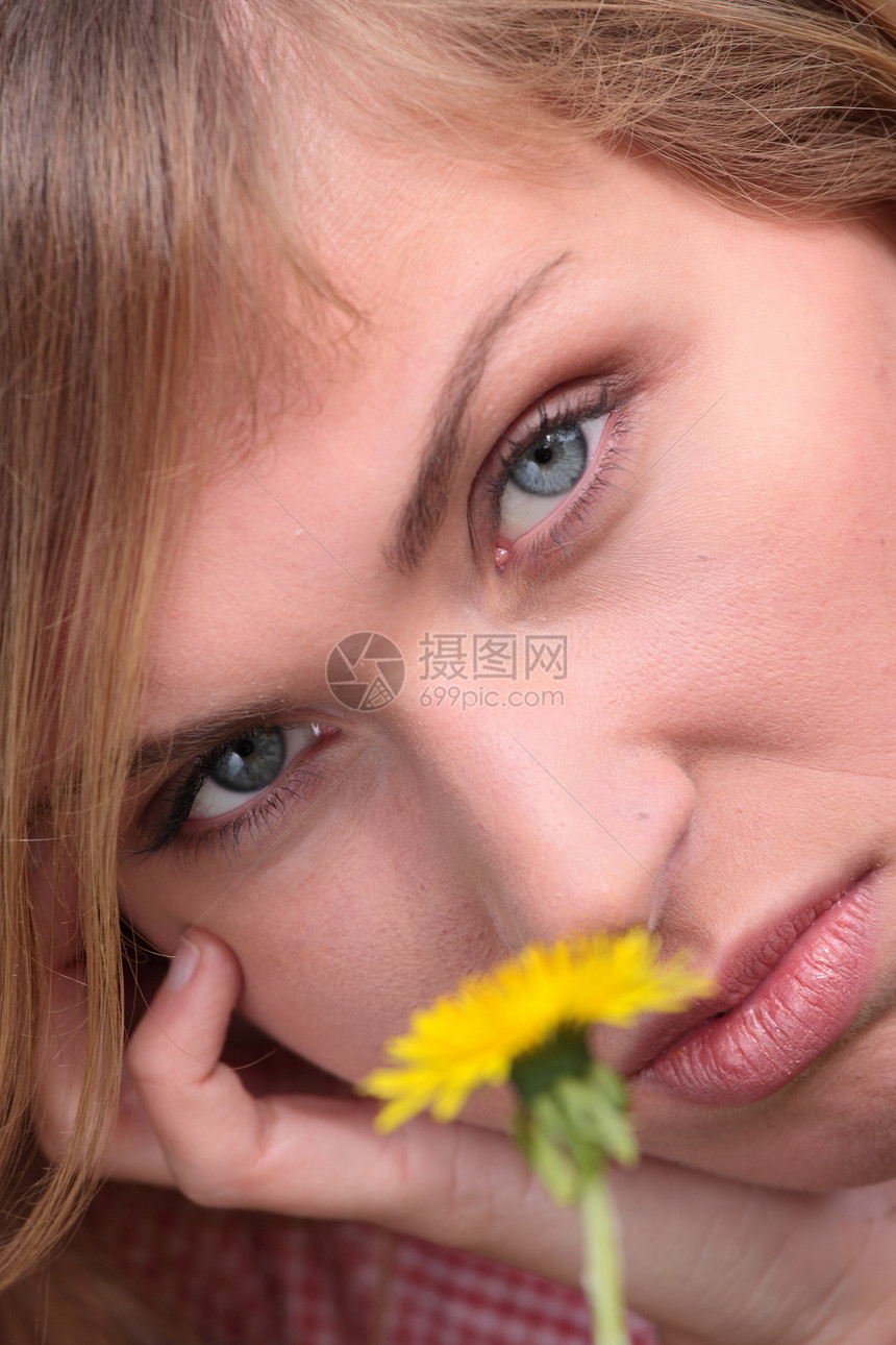美丽的女人在草地和鲜花中放松太阳生长紫外线魅力晴天温泉公园女士自由花园图片
