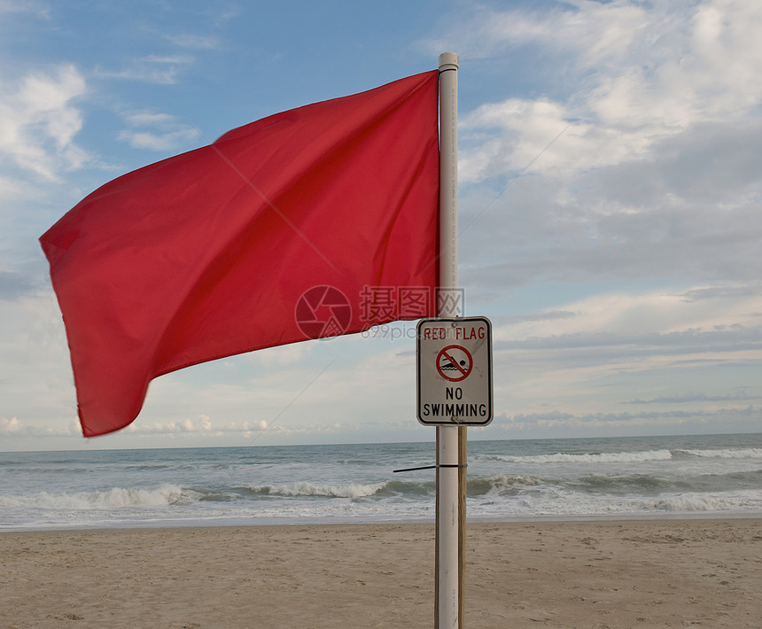 在海滩的红色警告旗帜图片