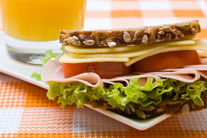 新鲜全餐奶酪和火腿三明治果汁火腿谷物蔬菜橙子种子美食面包午餐沙拉图片