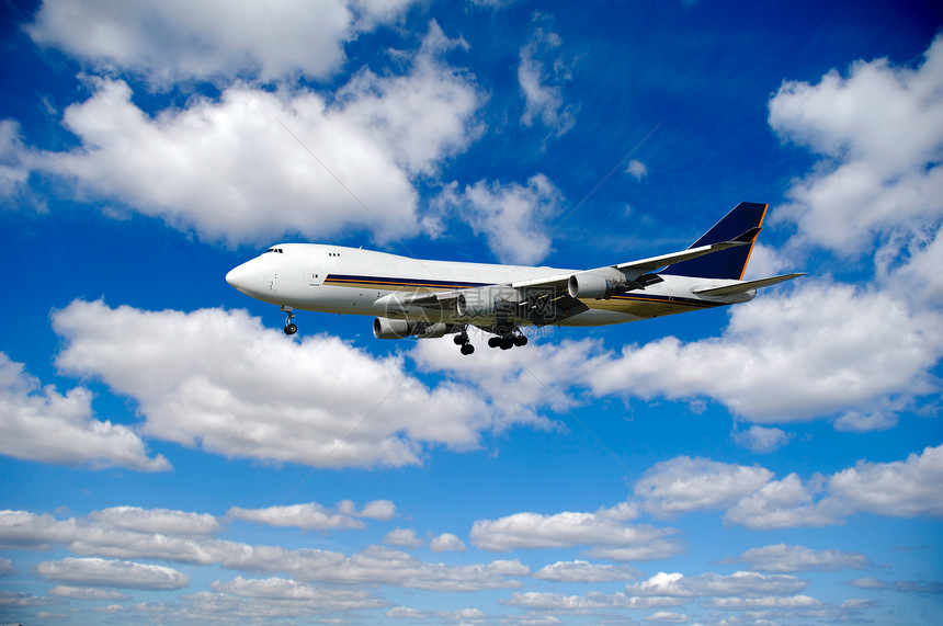 Jumbo和许多云彩土地喷射力量客机白色旅行翅膀涡轮运输蓝色图片