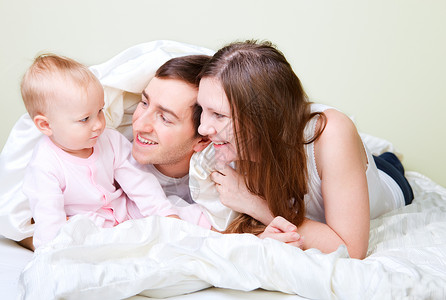 卧室中的家庭孩子妈妈爸爸童年父母团体母亲身份婴儿父亲享受高清图片素材