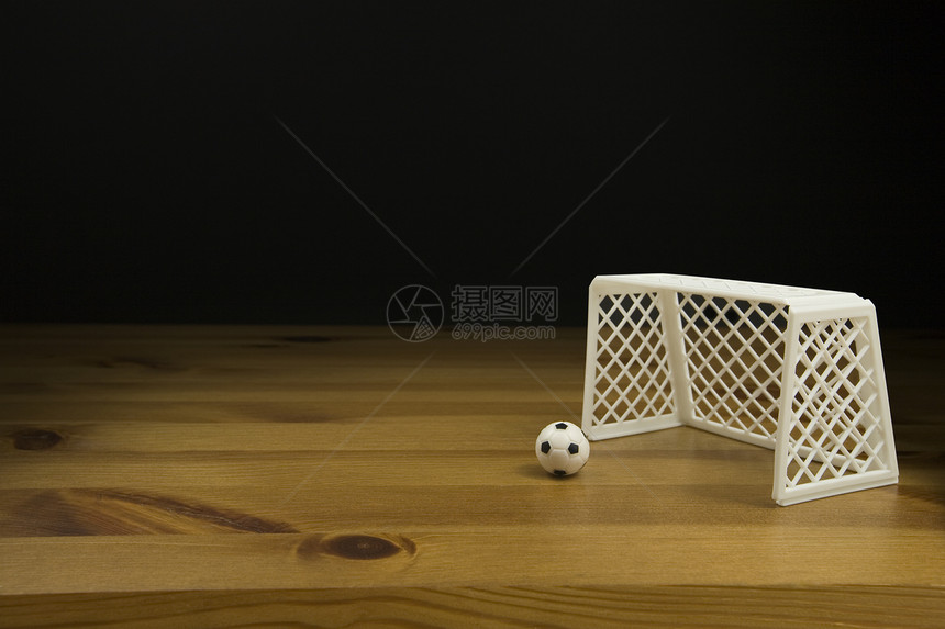 在木桌上贴近一张表 顶尖的足球和球门柱摄影桌子影棚深色水平背景图片