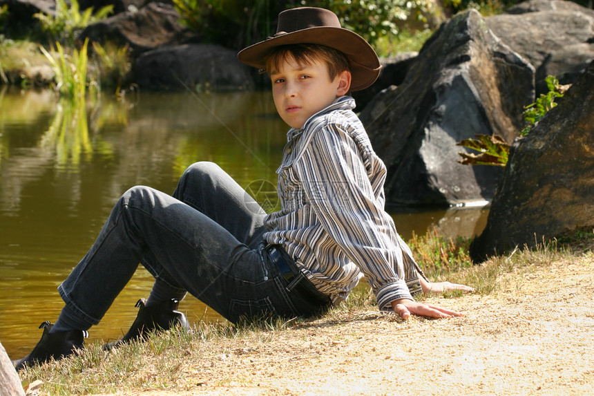 坐在河岸边的农村男孩图片