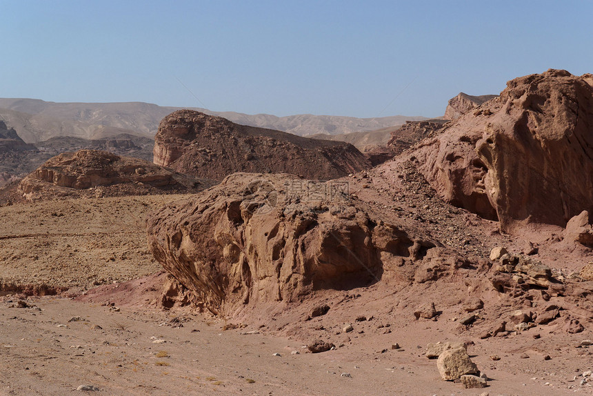 在石化沙漠中经风热的红色岩石图片